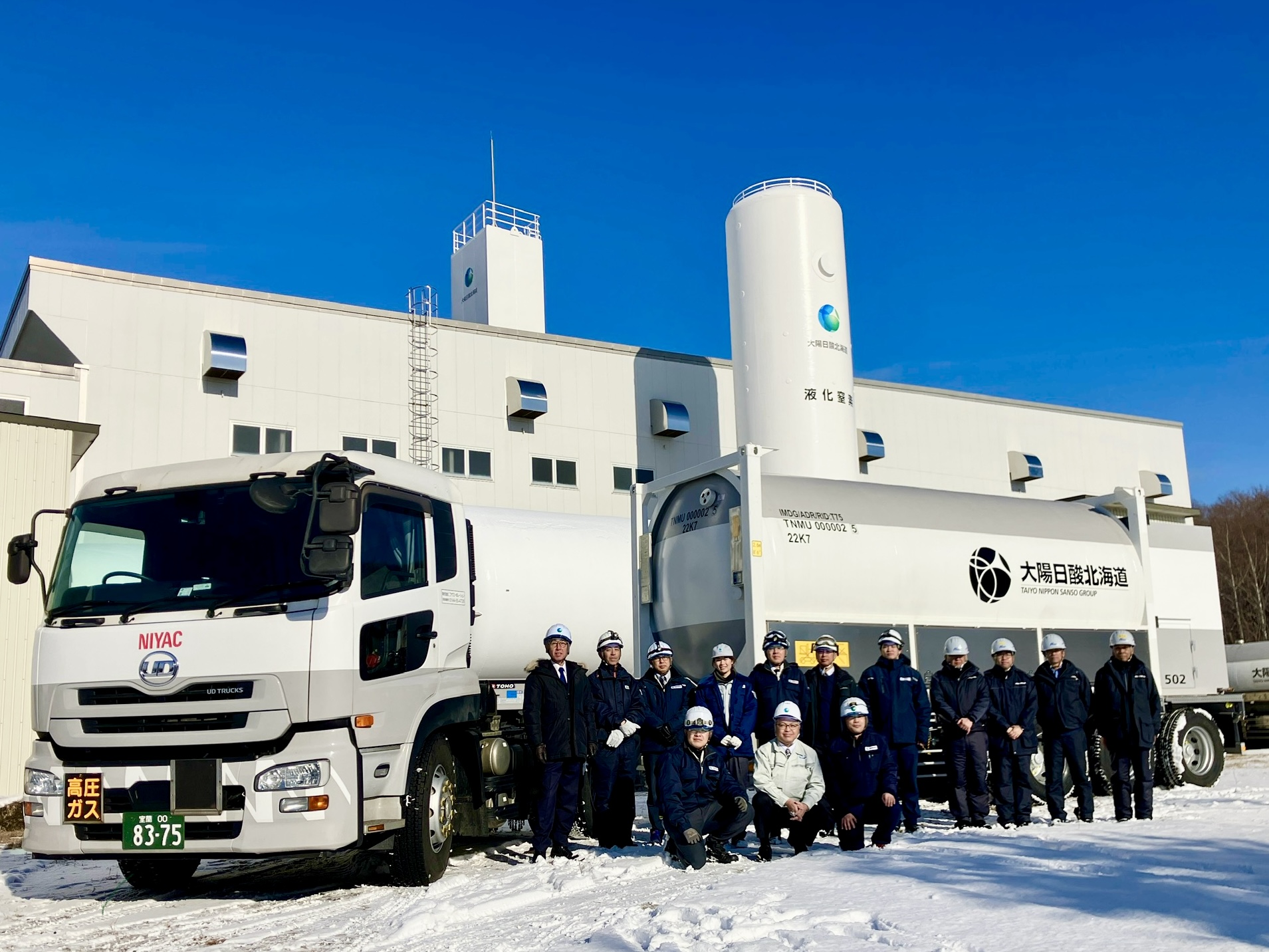 コンテナの前の関係者一同